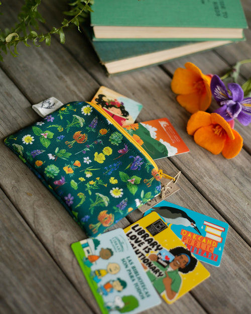 Load image 1 in gallery view. Native wildflower pouch with library cards and felt flowers around it on a wooden background. 
