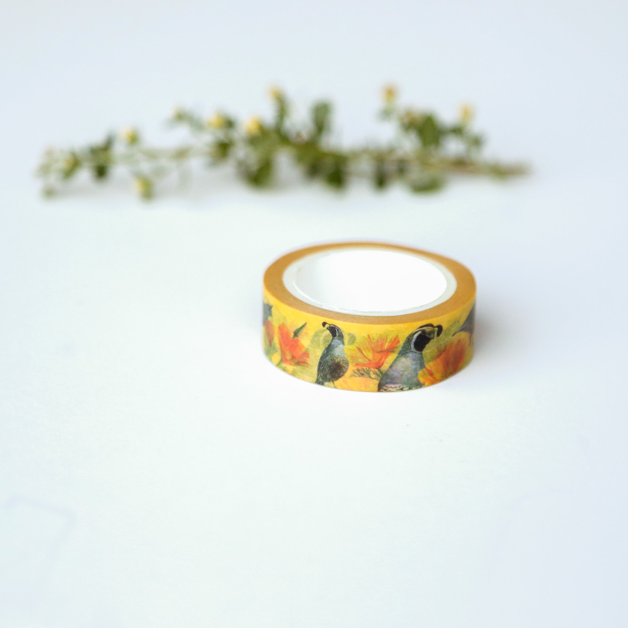 Roll of bright yellow tape printed with quails and poppies. 