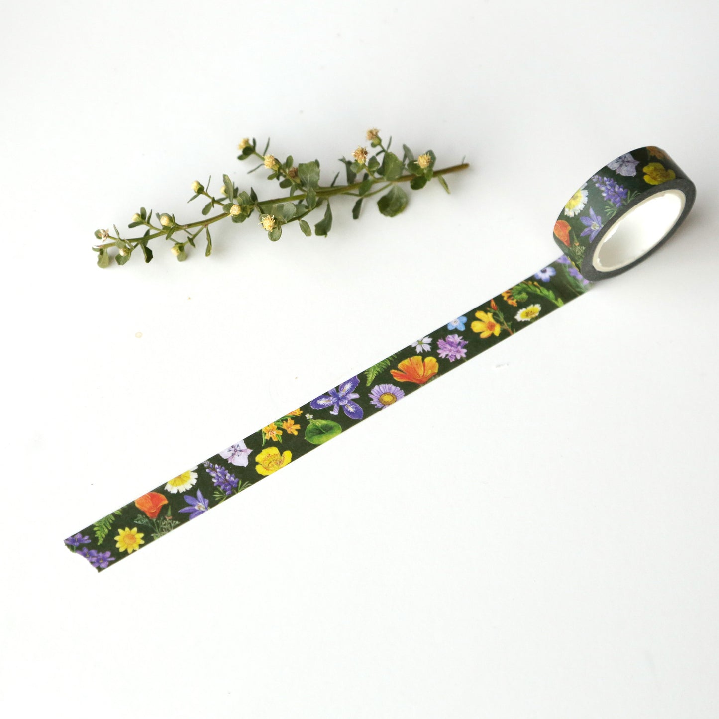Dark green tape unrolled to show various native wildflowers printed on it.